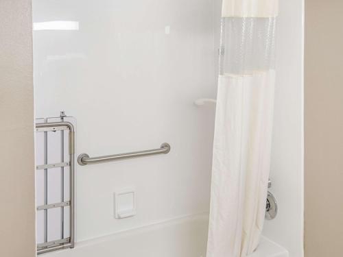 a white shower curtain in a bathroom with a tub at La Quinta by Wyndham Biloxi in Biloxi