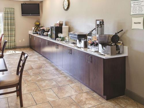 a counter in a coffee shop with a table and chairs at La Quinta by Wyndham Biloxi in Biloxi