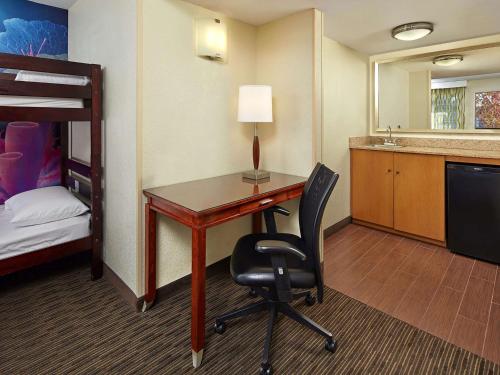 a room with a desk and a bed and a bunk bed at Mission View Inn & Suites San Diego Sea World - Zoo in San Diego