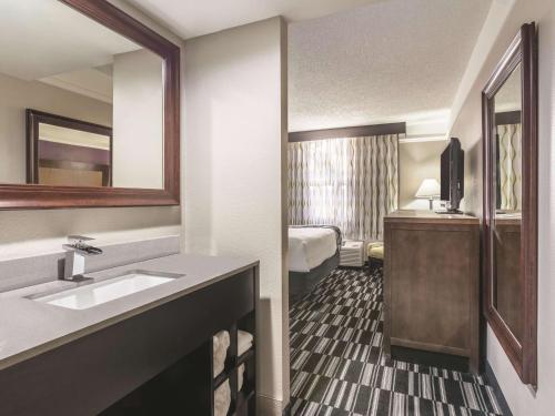 Habitación de hotel con lavabo y dormitorio en La Quinta Inn by Wyndham Jupiter en Jupiter