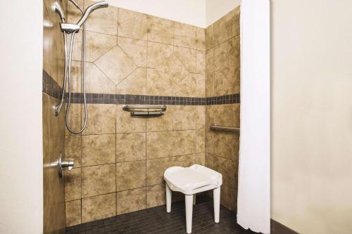 um chuveiro com um banco branco na casa de banho em La Quinta Inn by Wyndham Olympia - Lacey em Lacey