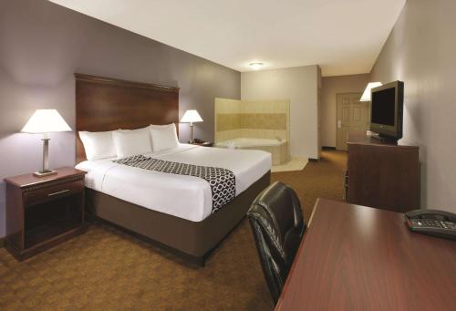 a hotel room with a large bed and a desk at La Quinta by Wyndham Corsicana in Corsicana