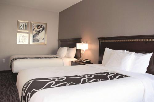 a hotel room with two beds and a lamp at La Quinta by Wyndham Abilene Mall in Abilene