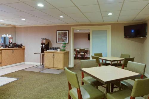 a waiting room with tables and chairs and a tv at La Quinta by Wyndham Lakeland East in Lakeland