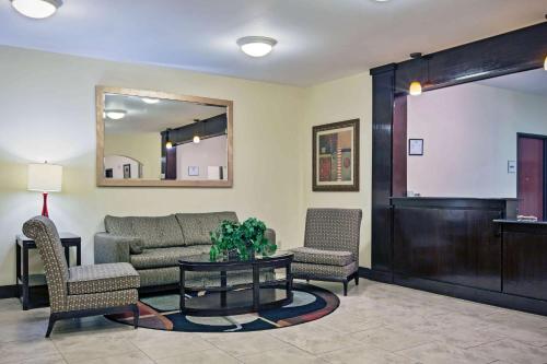 a living room with a couch and chairs and a table at La Quinta by Wyndham Morgan City in Morgan City