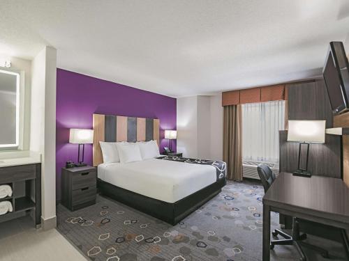 a hotel room with a bed and a desk at La Quinta by Wyndham Minneapolis Northwest in Brooklyn Park
