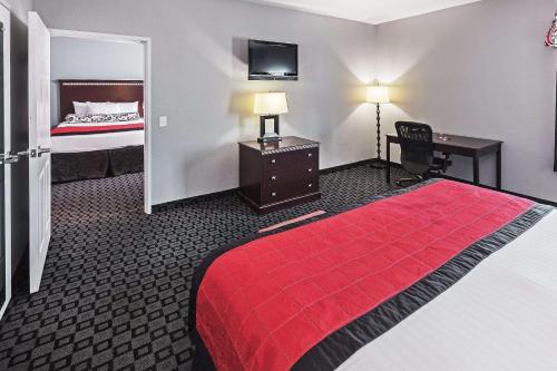 a hotel room with a red bed and a desk at La Quinta by Wyndham Decatur in Decatur