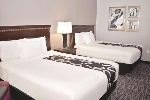 a hotel room with two beds and a lamp at La Quinta by Wyndham Abilene Mall in Abilene