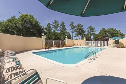 a swimming pool with chairs next to a fence at La Quinta by Wyndham N Little Rock - McCain Mall in Little Rock