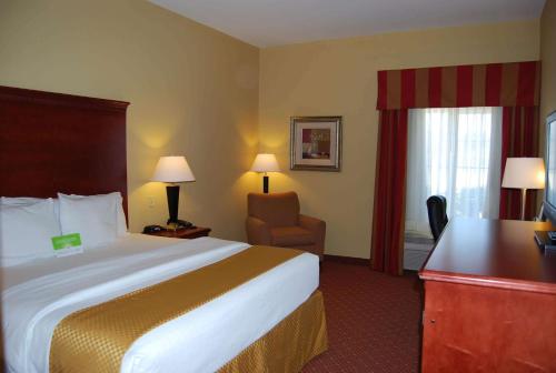 a hotel room with a large bed and a chair at La Quinta by Wyndham Fairfield TX in Fairfield