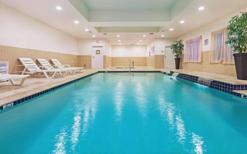 a pool with blue water in a hotel room at La Quinta by Wyndham Columbus TX in Columbus