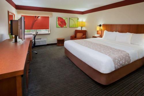 Habitación de hotel con cama grande y escritorio. en La Quinta by Wyndham Columbus State University, en Columbus