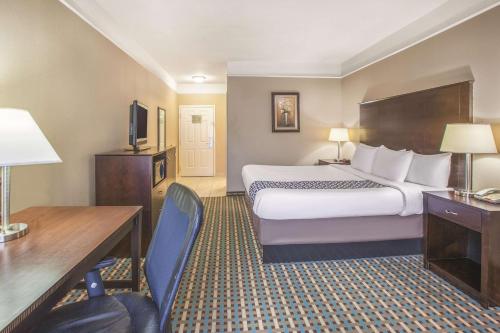 貝城的住宿－貝城拉金塔旅館及套房，酒店客房设有一张大床、一张书桌和一张书桌。
