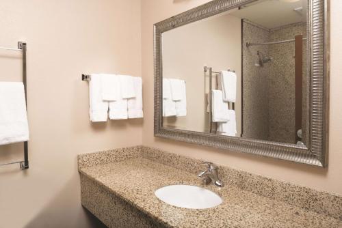 a bathroom with a sink and a mirror and towels at La Quinta by Wyndham Bozeman in Bozeman