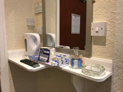 a bathroom with a sink and a mirror at Belmont Hotel in Blackpool