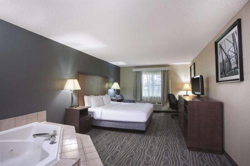 a hotel room with a bed and a bath tub at La Quinta Inn by Wyndham Richmond South in Chester