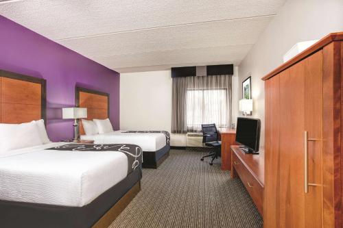 a hotel room with two beds and a television at La Quinta by Wyndham Atlanta Roswell in Roswell