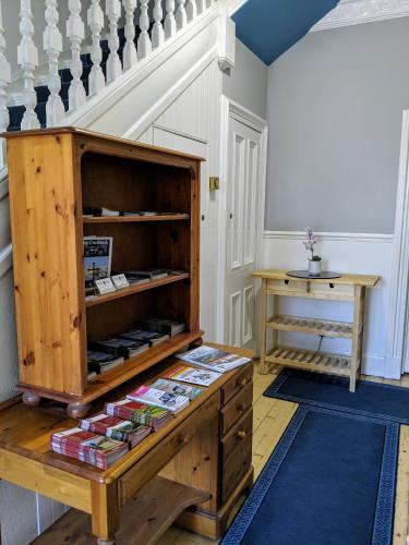 a room with a wooden book shelf with books at Falcon Crest Guest House in Edinburgh