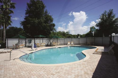 a large swimming pool with chairs and a fence at La Quinta by Wyndham Tampa Brandon West in Tampa