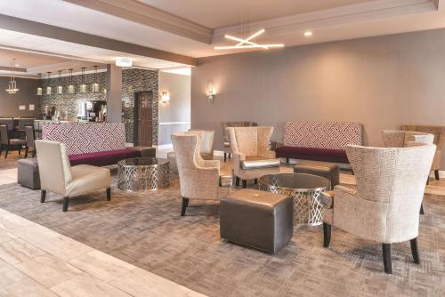 a lobby with chairs and tables and a bar at La Quinta by Wyndham Abilene Mall in Abilene