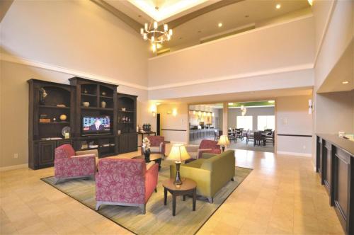 sala de estar con sofá, sillas y TV en La Quinta by Wyndham Brookshire West Katy en Brookshire