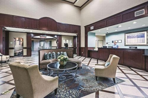 a lobby with chairs and a table and a bar at La Quinta by Wyndham DFW Airport West - Euless in Euless