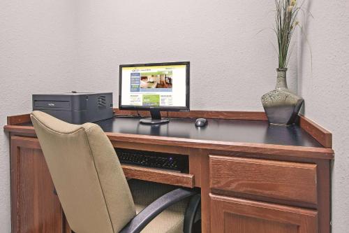 a desk with a computer and a vase on it at La Quinta by Wyndham DFW Airport West - Euless in Euless