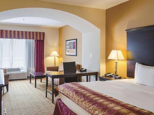 a hotel room with a bed and a desk at La Quinta by Wyndham Mobile Satsuma / Saraland in Satsuma