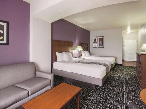 a hotel room with two beds and a couch at La Quinta by Wyndham Bowling Green in Bowling Green