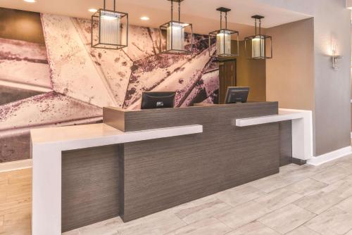 a reception desk in a lobby with a painting at La Quinta by Wyndham Abilene Mall in Abilene