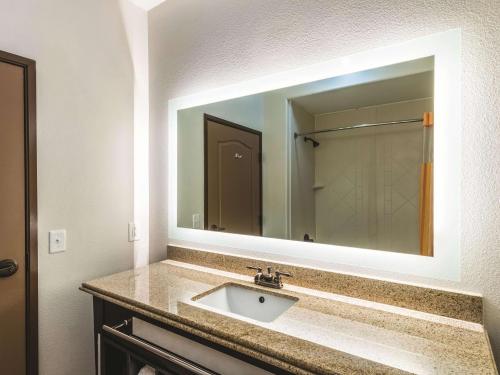 a bathroom with a sink and a large mirror at La Quinta by Wyndham Dallas Grand Prairie South in Grand Prairie