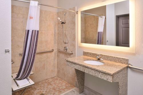 a bathroom with a shower and a sink and a mirror at La Quinta by Wyndham Abilene Mall in Abilene