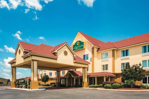 a hotel with a sign on the front of it at La Quinta by Wyndham Russellville in Russellville