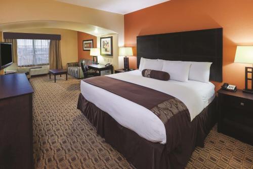 a hotel room with a large bed and a desk at La Quinta by Wyndham Searcy in Searcy