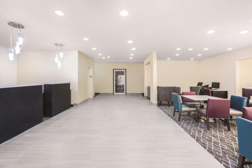 una sala d'attesa vuota con tavoli e sedie di La Quinta by Wyndham Rome a Rome