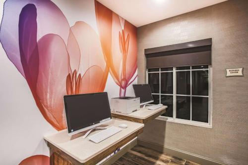 an office with two desks with computers and a flower mural at La Quinta by Wyndham Chambersburg in Chambersburg
