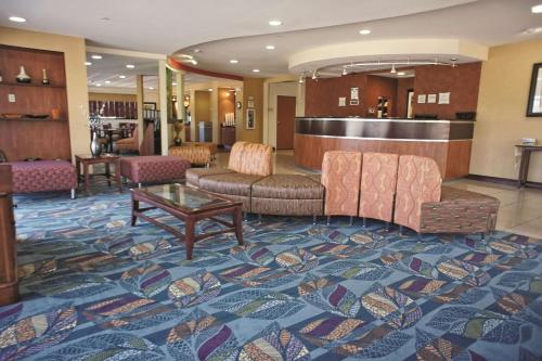 a lobby with couches and a table on a rug at La Quinta by Wyndham Edmond in Edmond