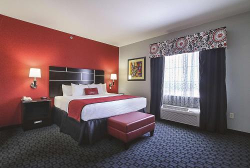 a hotel room with a large bed and a window at La Quinta Inn & Suites by Wyndham South Dallas - Hutchins in Hutchins