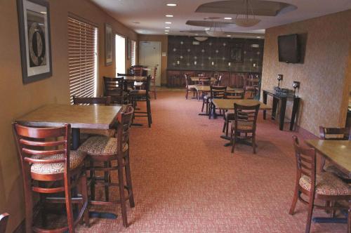 een eetkamer met tafels en stoelen en een bibliotheek bij La Quinta by Wyndham Bismarck in Bismarck