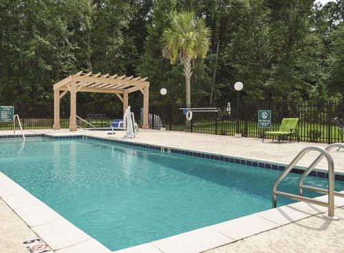a swimming pool with a gazebo and a woman in a wedding dress at La Quinta by Wyndham Mobile Satsuma / Saraland in Satsuma
