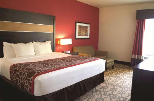 a hotel room with a large bed and a chair at La Quinta by Wyndham Pearsall in Pearsall