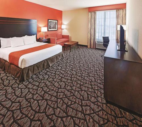 a hotel room with a bed and a television at La Quinta by Wyndham Pecos in Pecos