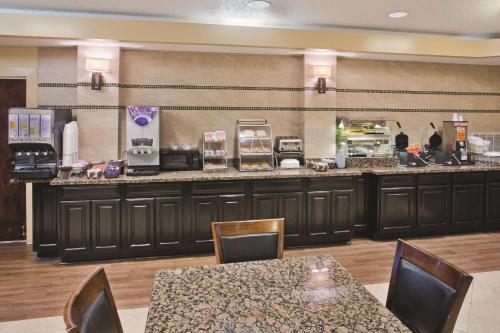 a restaurant with a counter with tables and chairs at La Quinta by Wyndham Hot Springs in Hot Springs