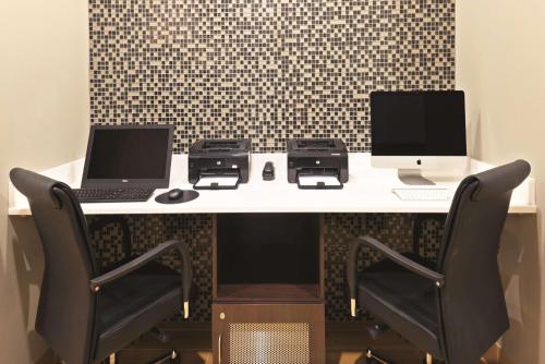 a desk with two laptops and printers on it at La Quinta by Wyndham Billings in Billings