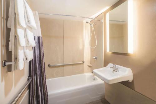 a bathroom with a sink and a tub and a toilet at La Quinta by Wyndham Brooklyn Downtown in Brooklyn