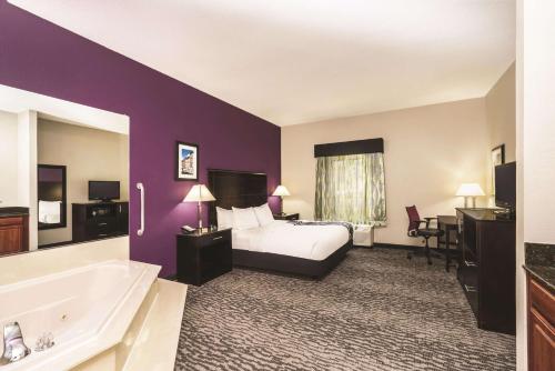 a hotel room with a bed and a bath tub at La Quinta Inn & Suites by Wyndham Louisville East in Louisville