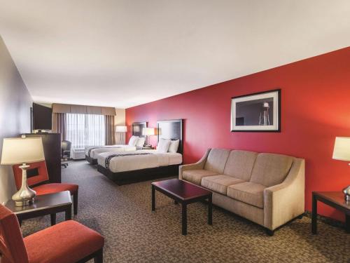 a hotel room with two beds and a couch at La Quinta by Wyndham Fargo-Medical Center in Fargo