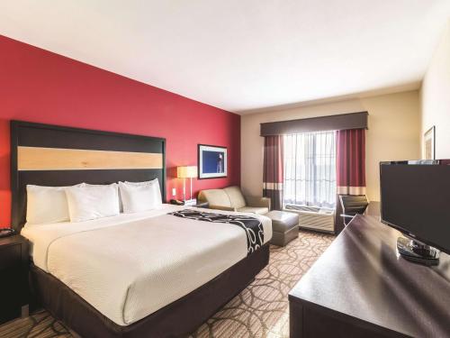 a hotel room with a bed and a flat screen tv at La Quinta by Wyndham Fargo-Medical Center in Fargo