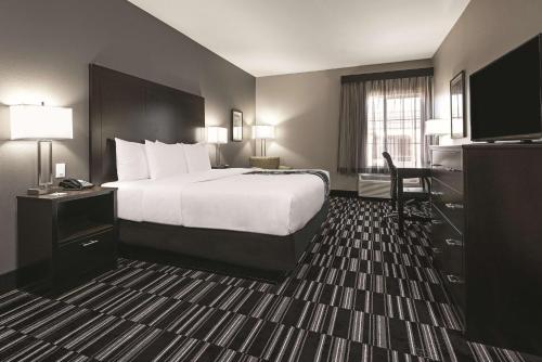a hotel room with a bed and a desk at La Quinta by Wyndham Fort Worth West - I-30 in Fort Worth