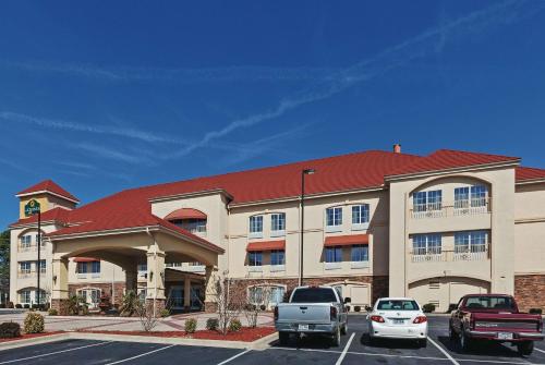 a hotel with cars parked in a parking lot at La Quinta by Wyndham Searcy in Searcy